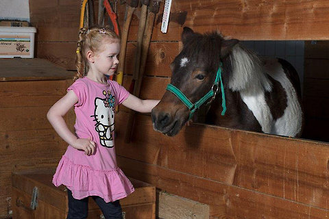 Kind mit Pony auf dem Ferienhof in Bayern
